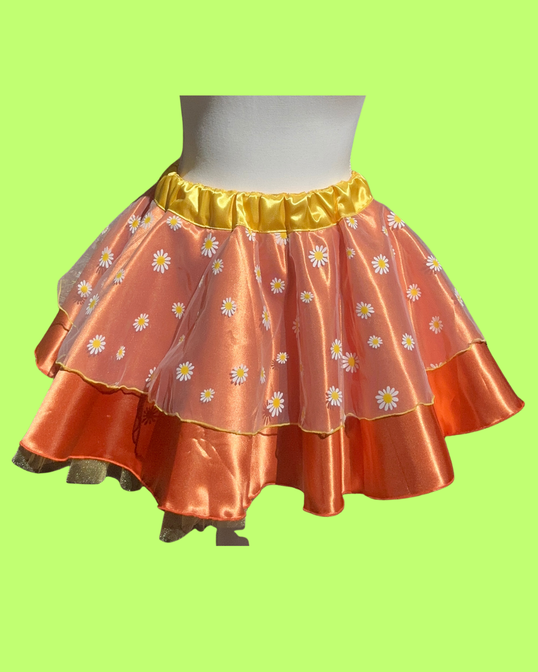 Two-layered orange bird running skirt with floral pattern on a green background