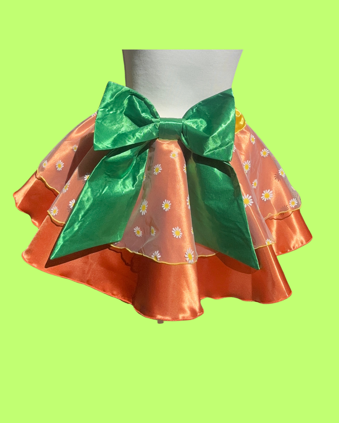 orange bird running Skirt with a large green bow on a mannequin against a bright green background