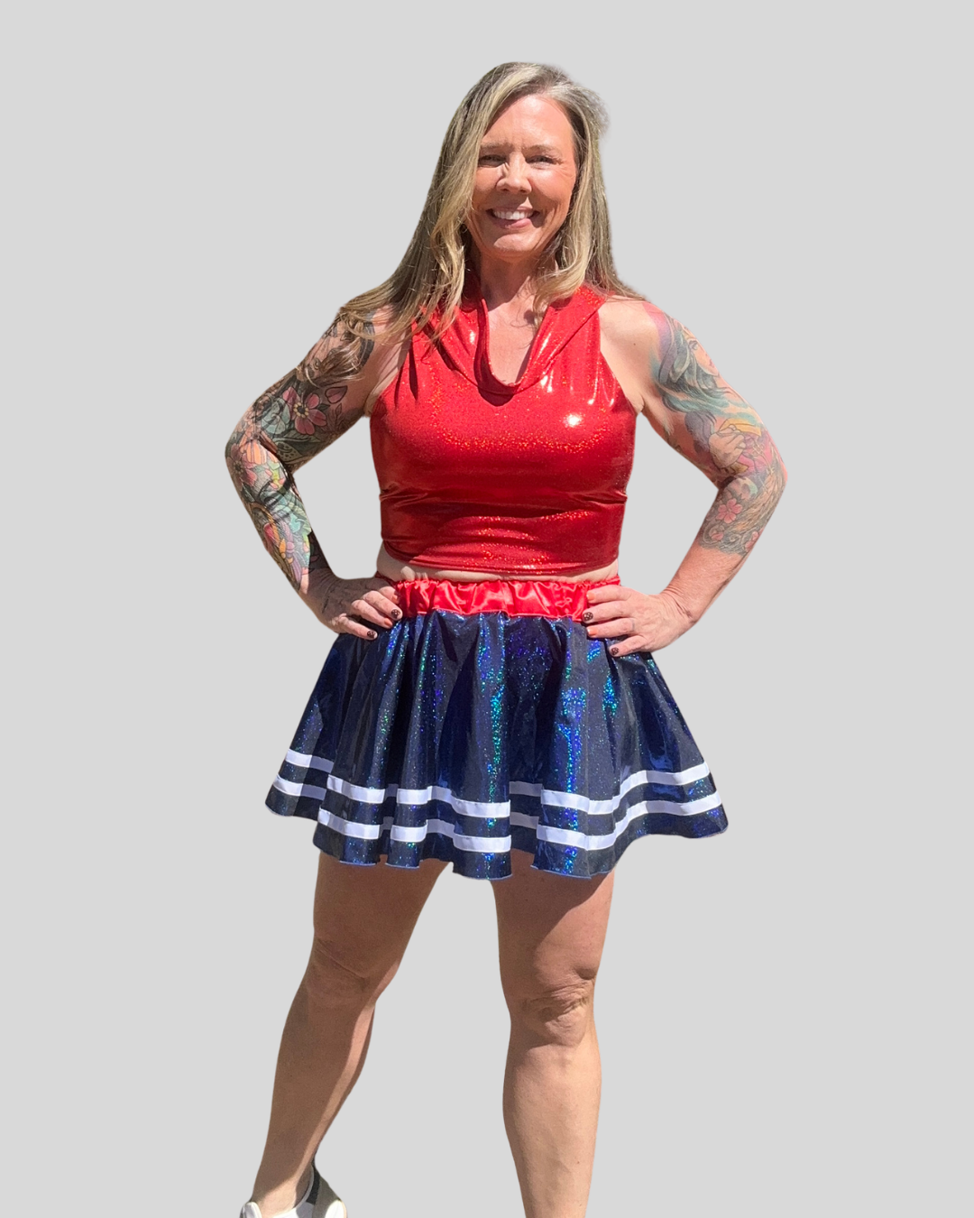 Woman wearing a red top and blue skirt with white stripes on a gray background