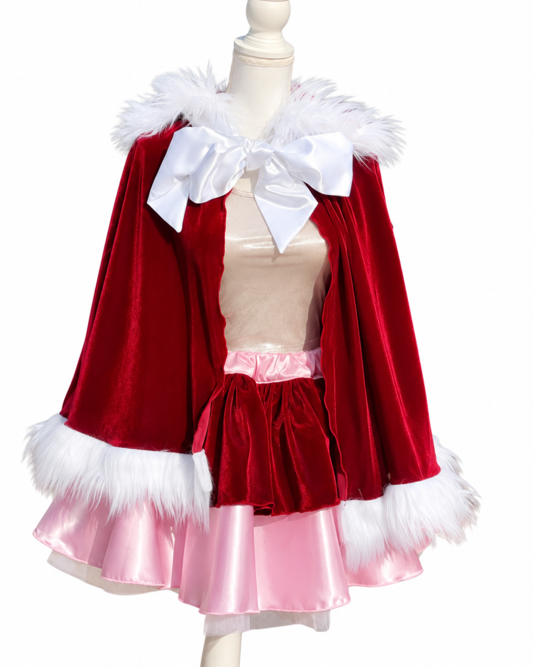 Burgundy velvet Christmas cape with white faux fur trim and white satin bow paired with a pink and burgundy running skirt.