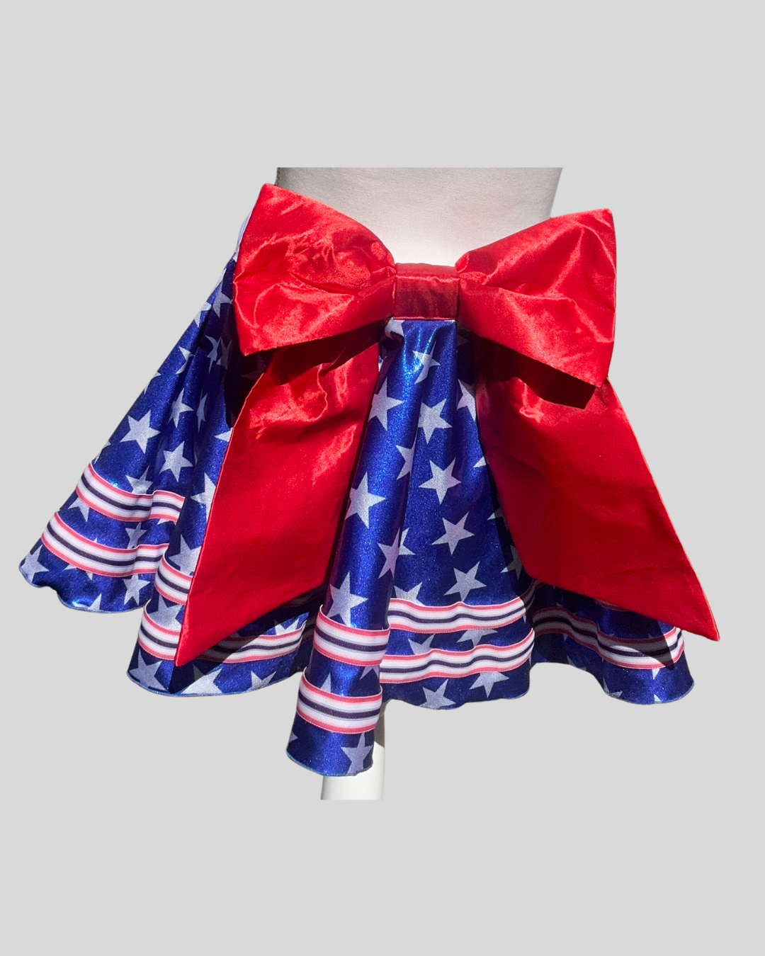 back view sparkly royal blue with white stars running skirt with red waistband and bow, versatile patriotic running outfit