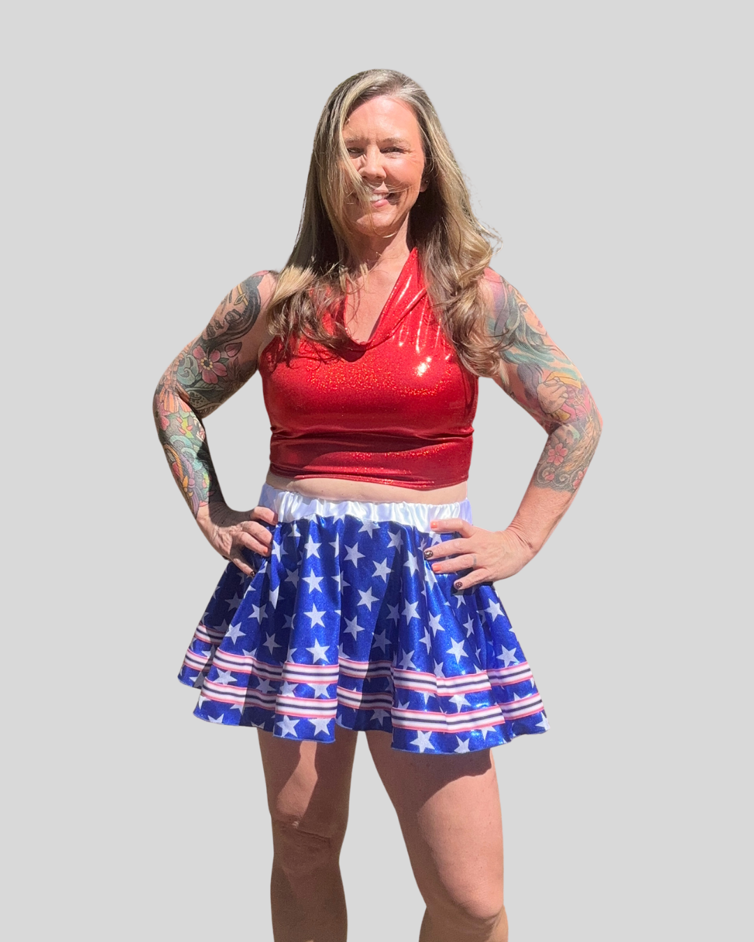 Woman wearing a red top and blue star-patterned running skirt against a plain background