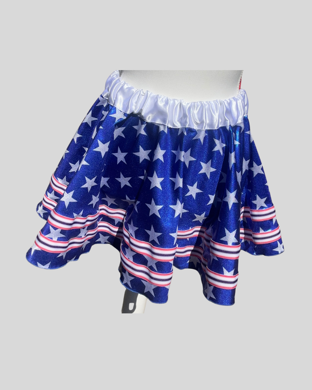 front view sparkly royal blue with white stars running skirt with red waistband and bow, versatile patriotic running outfit