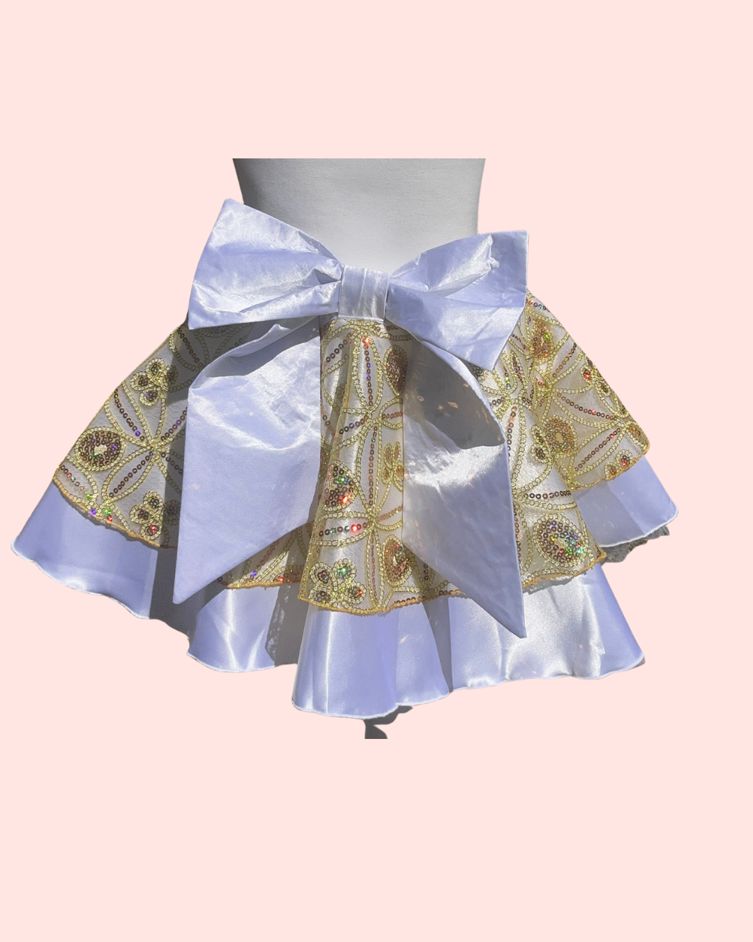 Cake Bake Skirt with decorative patterns and a large bow on a pink background