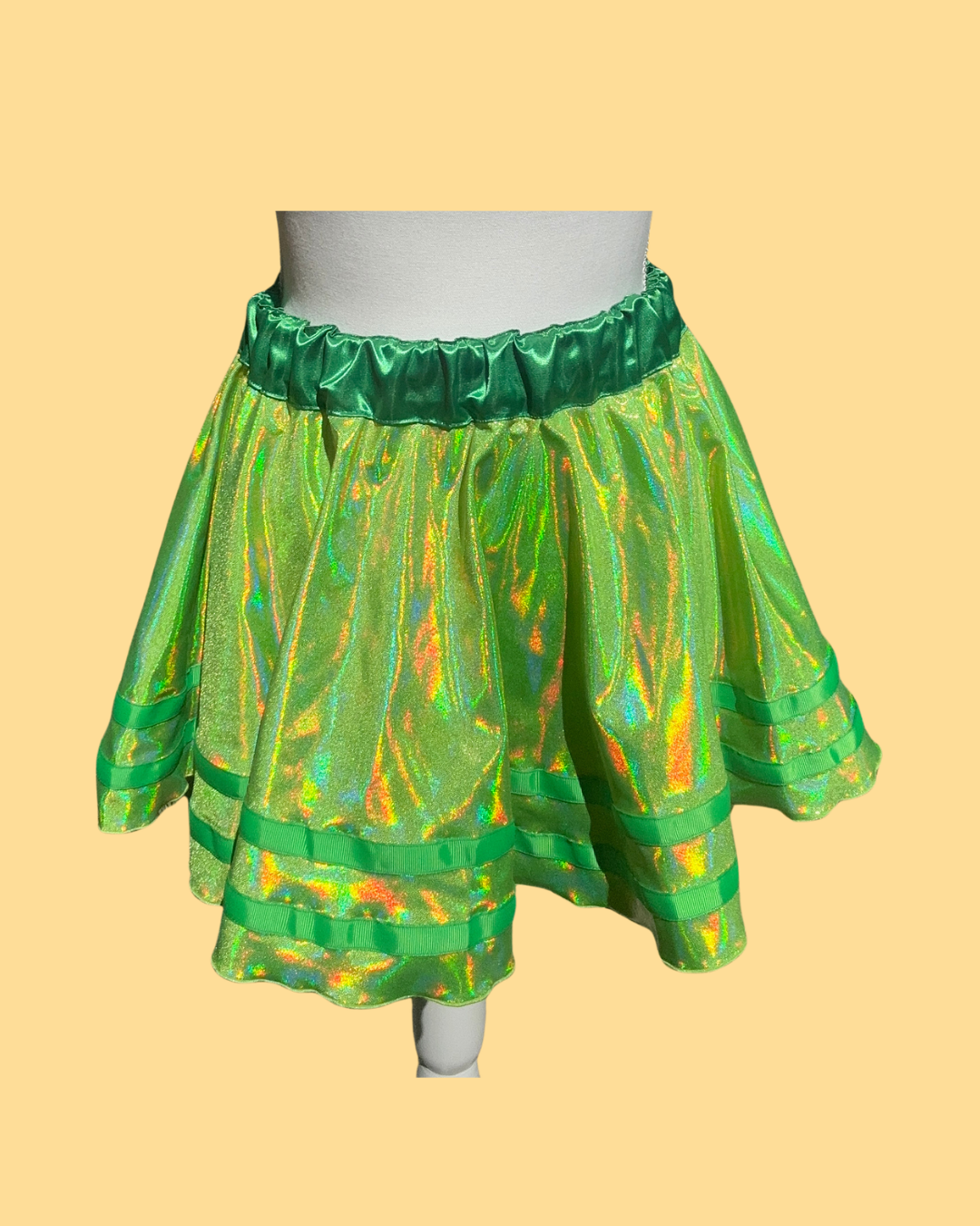 Green and multicolored running skirt on a mannequin against a beige background